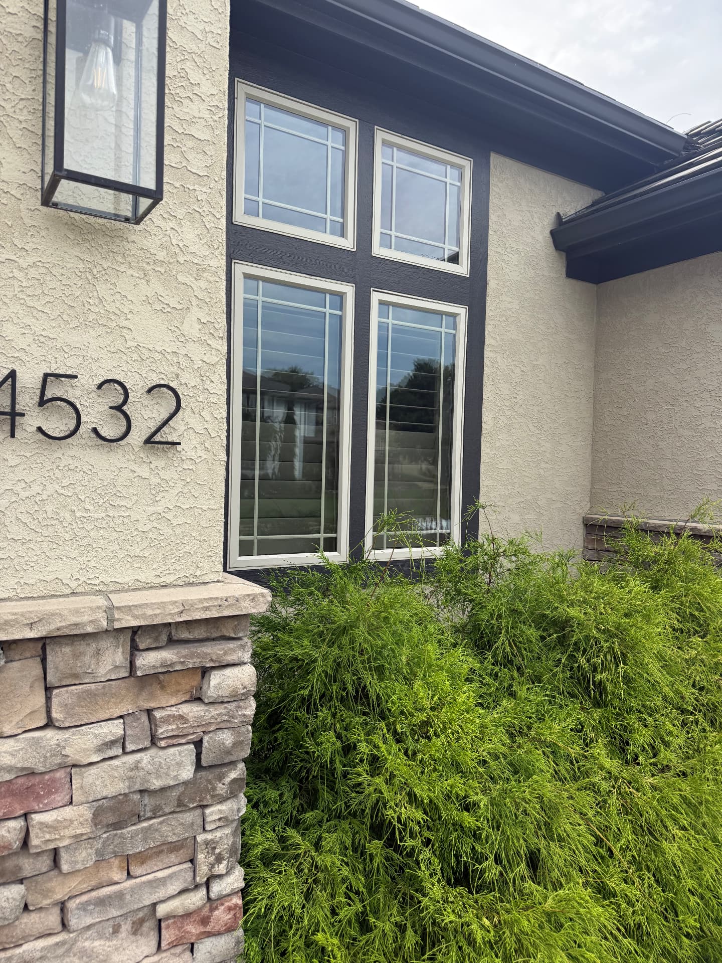 Streak-free grid windows on a cream stucco home with dark trim